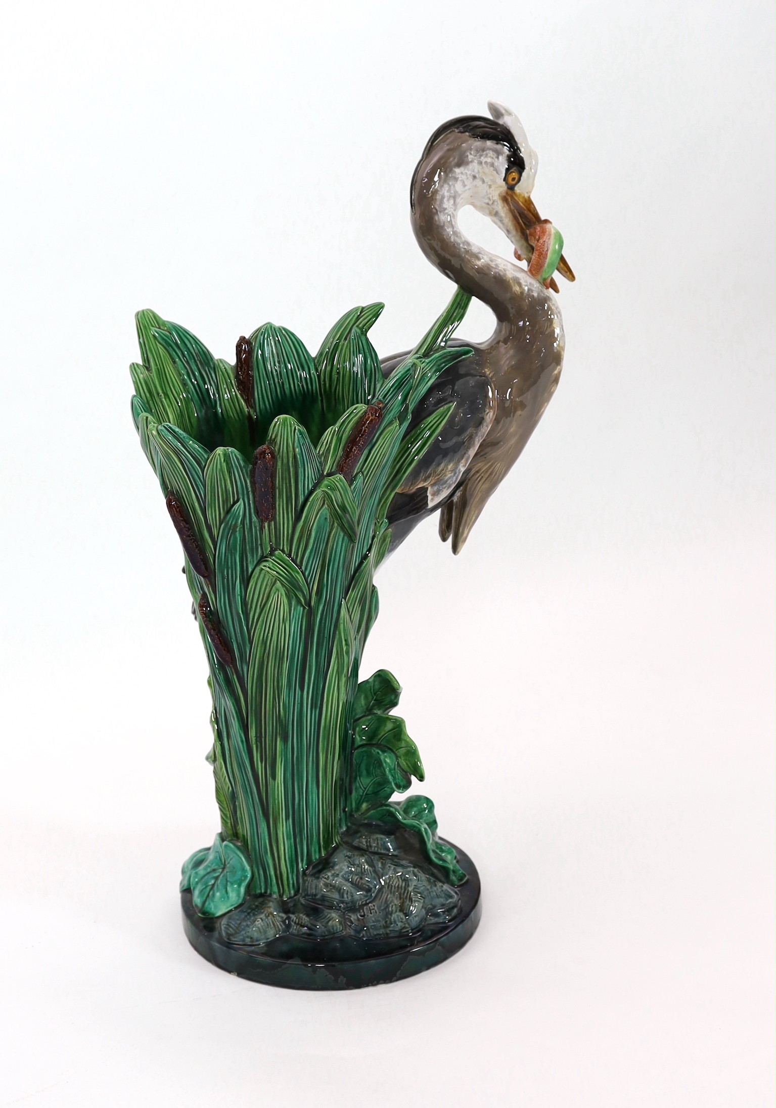 A Minton majolica life-size ‘heron’ stickstand, initialled J.H. for the modeller John Henk, c.1905, 44cm wide 76cm high